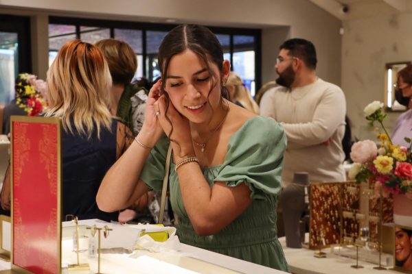 Student designer and senior Kaylee Martinez tries on the earrings she designed named the Murphy studs on February 6, 2024. Martinez and her design team consisting of other UT students were being honored at the Kendra Scott Flagship Store on South Congress.