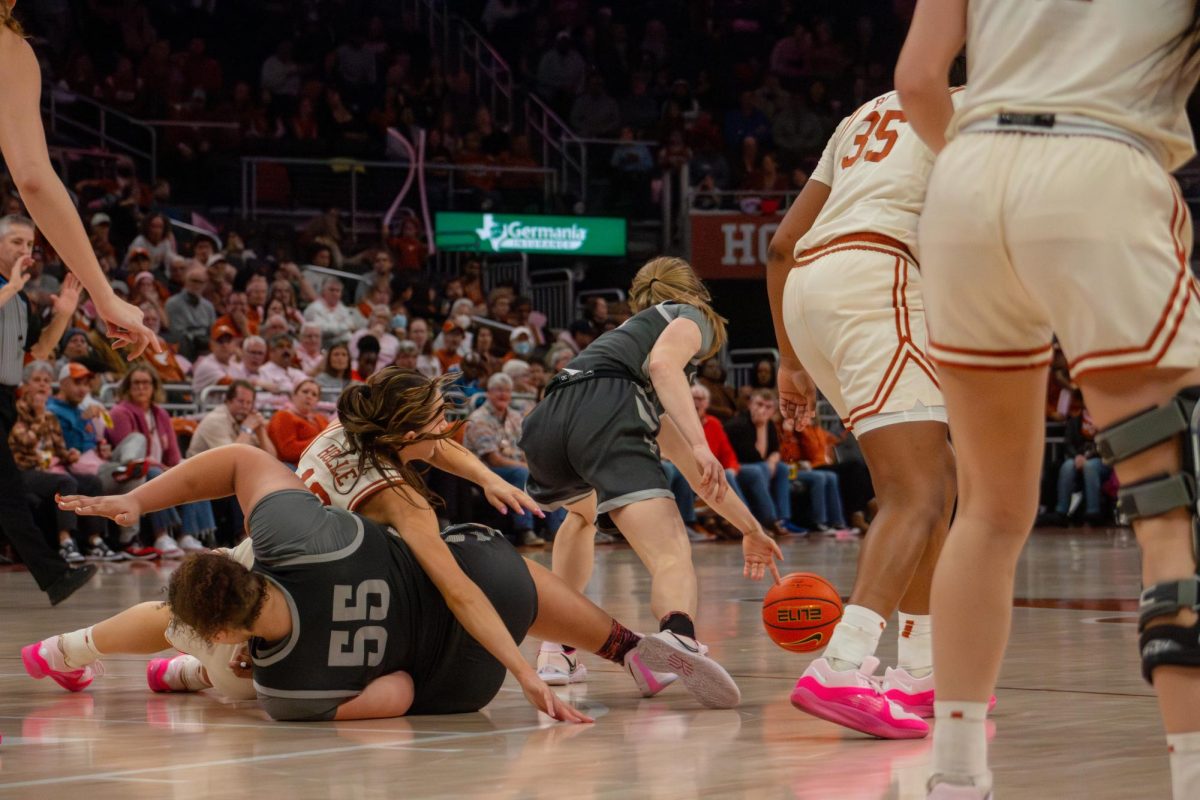 Shay Holle falls while attempting to steal the ball during Texas game against Iowa State on Saturday.