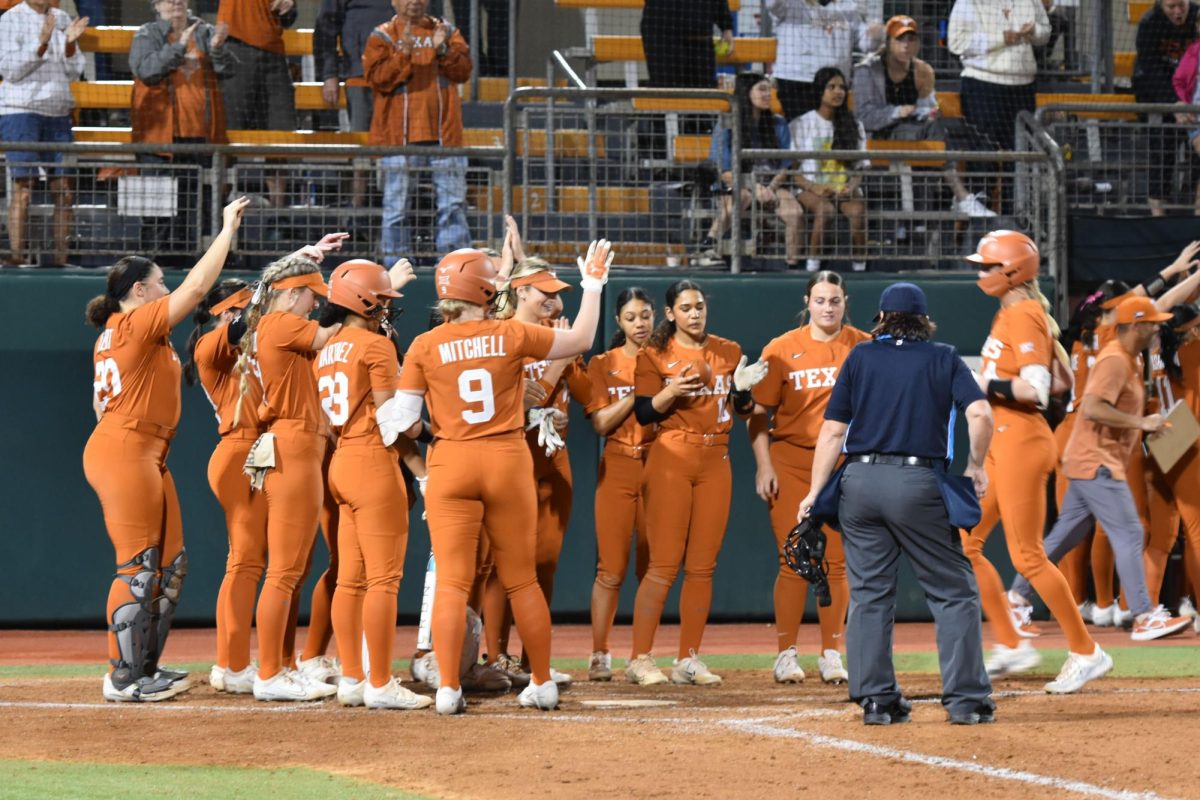 The Texas Softball team waits for sophomore Reese Atwood at home plate after she hit a home run on Feb. 23, 2024. Atwood had 2 hits and 2 runs at this game against Colorado State to contribute to the Longhorns 7-0 win in the Lone Star State Invitational.