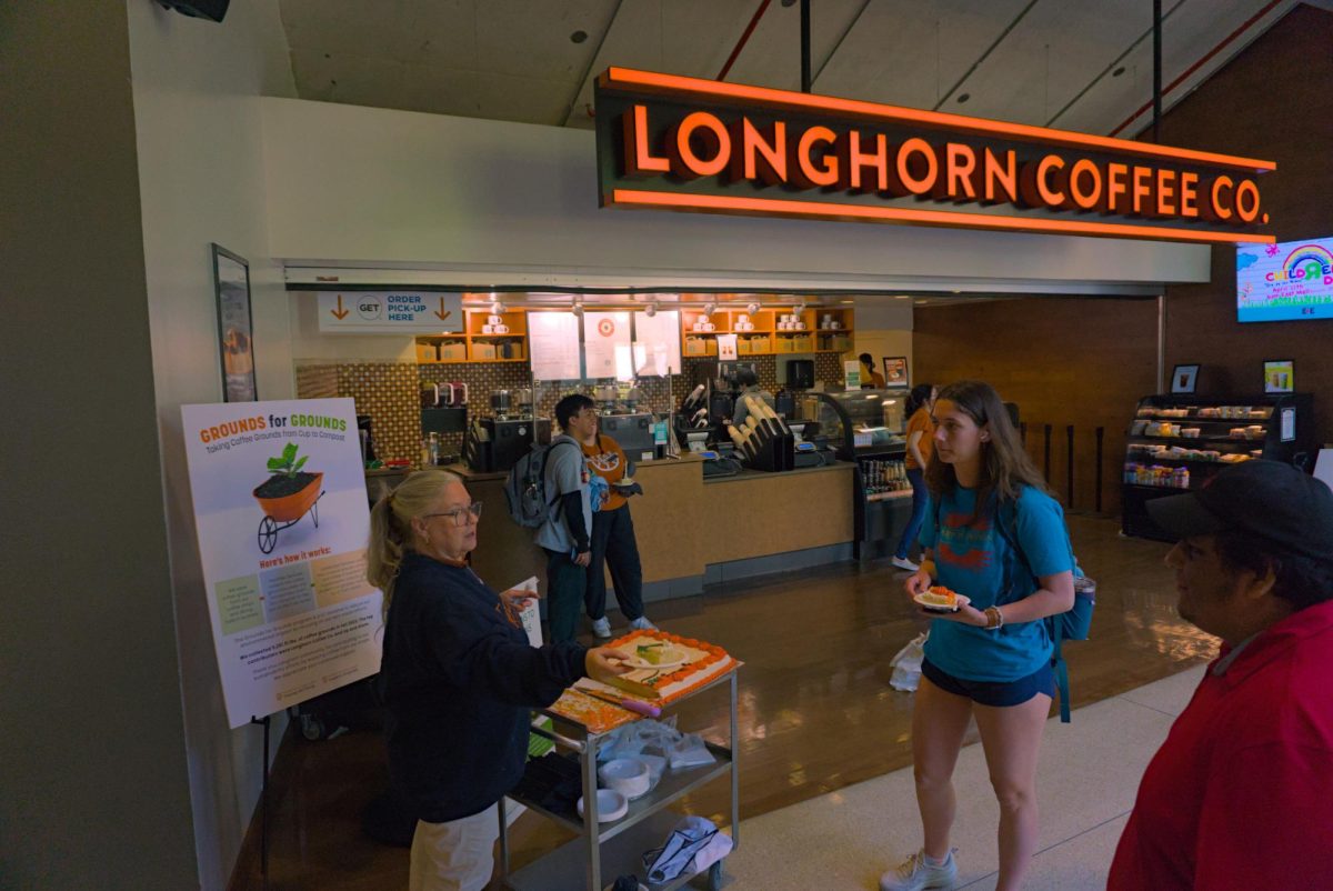 Coffee brand manager Christina Pearce hands out cake to students passing by on the celebration of Grounds for Grounds on Tuesday at the WCP Longhorn Coffee Co. Pearce is responsible for managing the coffee shops and brands located inside the campus buildings at UT.