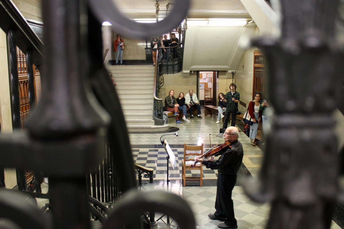 UT Psychology professor Michael Domjan plays the music of German composer Johann Sebastian Bach on the solo viola on Tuesday. Cello Suite No. 1 and other Bach pieces echoed up the Main Building stairs as students gathered to listen.