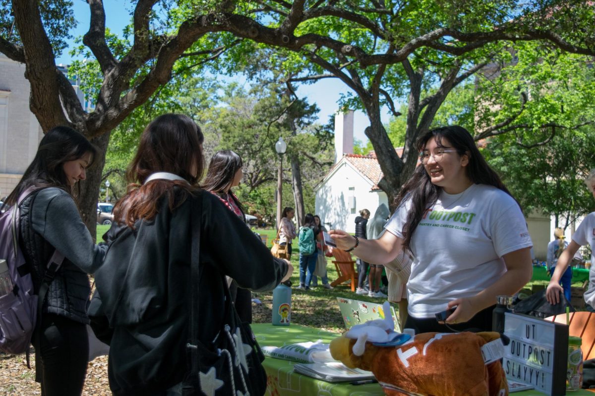 Junior Stefania Alarcon welcomes a student to the UT Outpost Outside event at the Turtle Pond on Tuesday, March 26, 2024. The event featured activities such as friendship bracelet making and provided snacks to promote the school’s free food pantry.