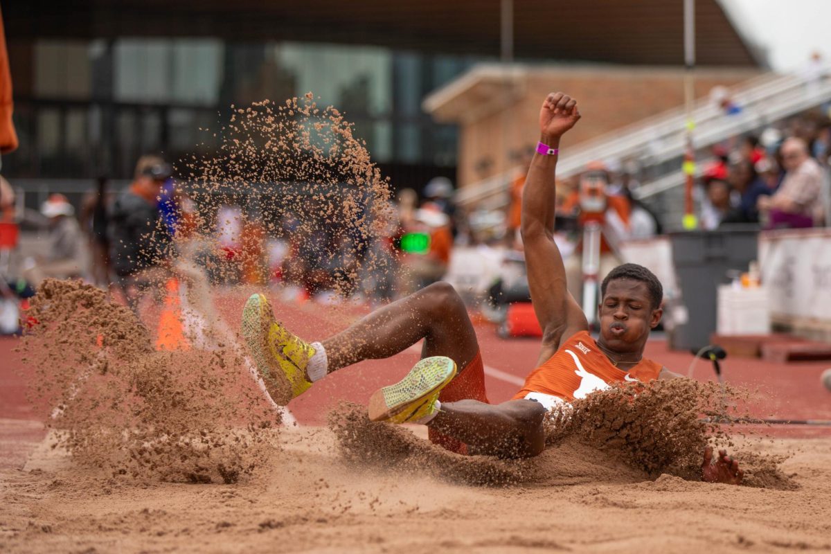 Junior Solomon Washington lands in the sand pit while competing in the triple jump at the Clyde Littlefield Texas Relays on March 30, 2024. Washington jumped 14.67 meters.