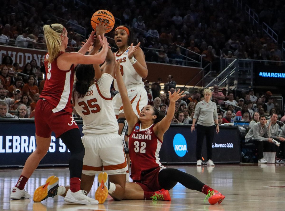 Forwards Madison Booker and Aaliyah Moore scramble for the ball on March 24, 2024. The Longhorns defeated Alabama to advance to the Sweet Sixteen round of the March Madness tournament.