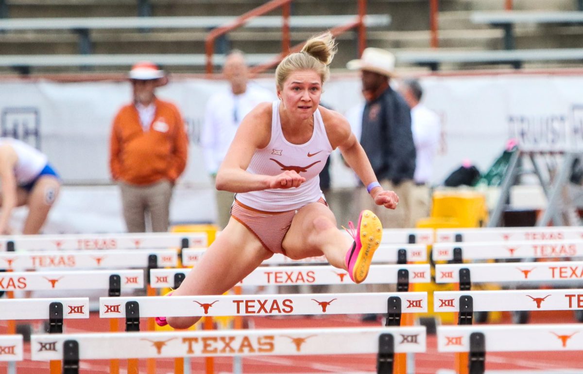 Senior Kristine Blazevica jumps over a hurdle during the 100-meter hurdle event of the heptathlon. Blazevica placed third in the heptathlon with 5,662 points.