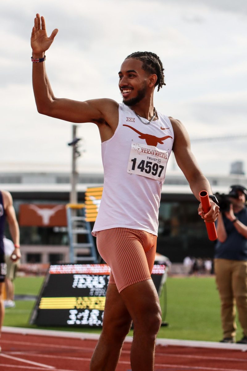 Senior Yusuf Bizimana waves to the crowd after running the anchor leg of the sprint medley relay on March 29, 2024, at the Clyde Littlefield Texas Relays. Bizimana led his relay team to a first place finish, with a final time of 3:15.03.