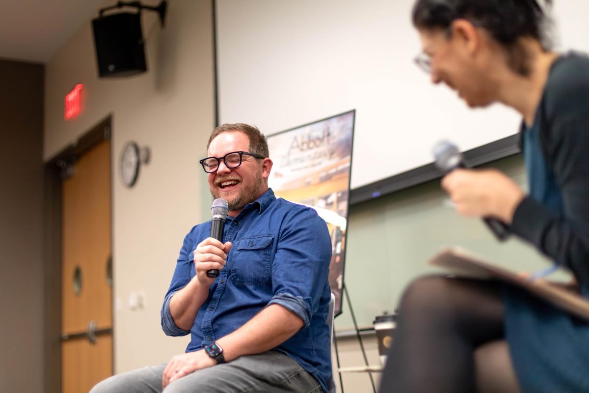 Abbott Elementary showrunner Patrick Schumaker and UT professor Alisa Perren laugh Monday during an interview panel at the Moody College of Communication.