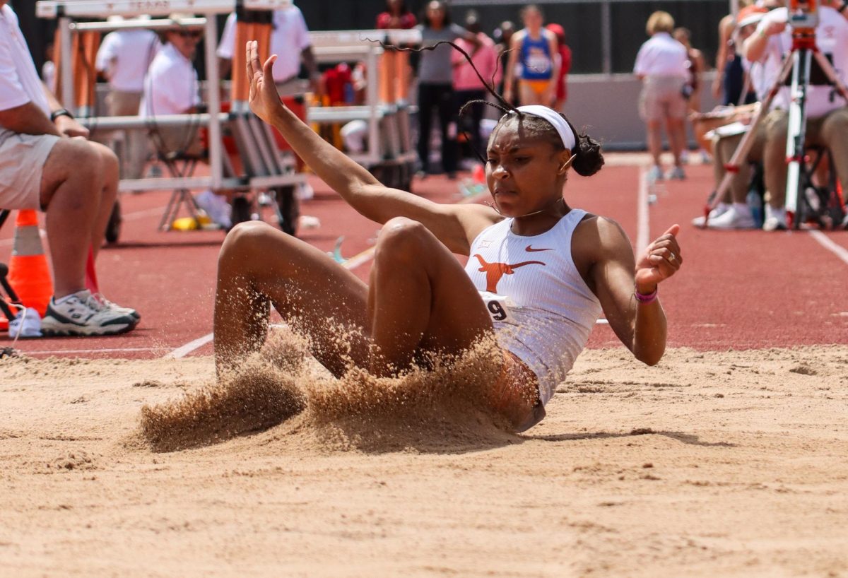 Freshman Aaliyah Foster lands in the sand pit while competing in long jump at the Clyde Littlefield Texas Relays. Foster placed first with her jump of 6.75 meters.