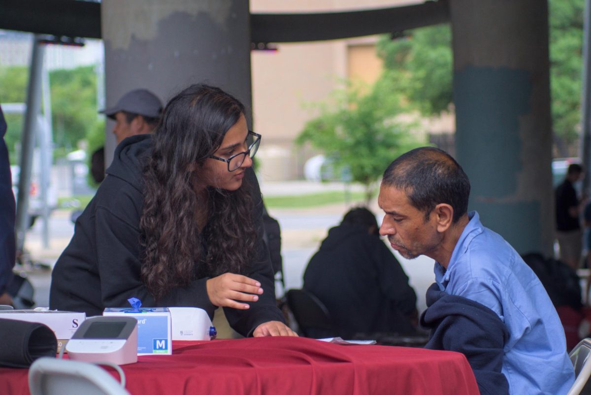 Public Health sophomore Arushi Shyam explains a mans vitals at the Church Under the Bridge on Sunday. The Hearts for the Homeless student organization takes vital signs and provides education for the less fortunate on heart health on several occasions each week.
