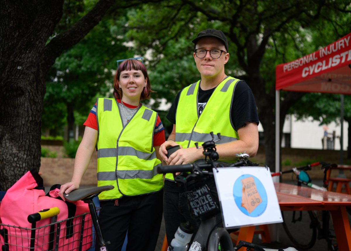 Co-founders of Austin Bicycle Meals, Claire Harbutt and Kelly Wourms stand for a portrait at their Bike to UT Day stall. Austin Bicycle Meals is a non-profit that passes out food, water, menstrual kits and other essentials to unhoused people in Austin on alternate Wednesdays and every Saturday.
