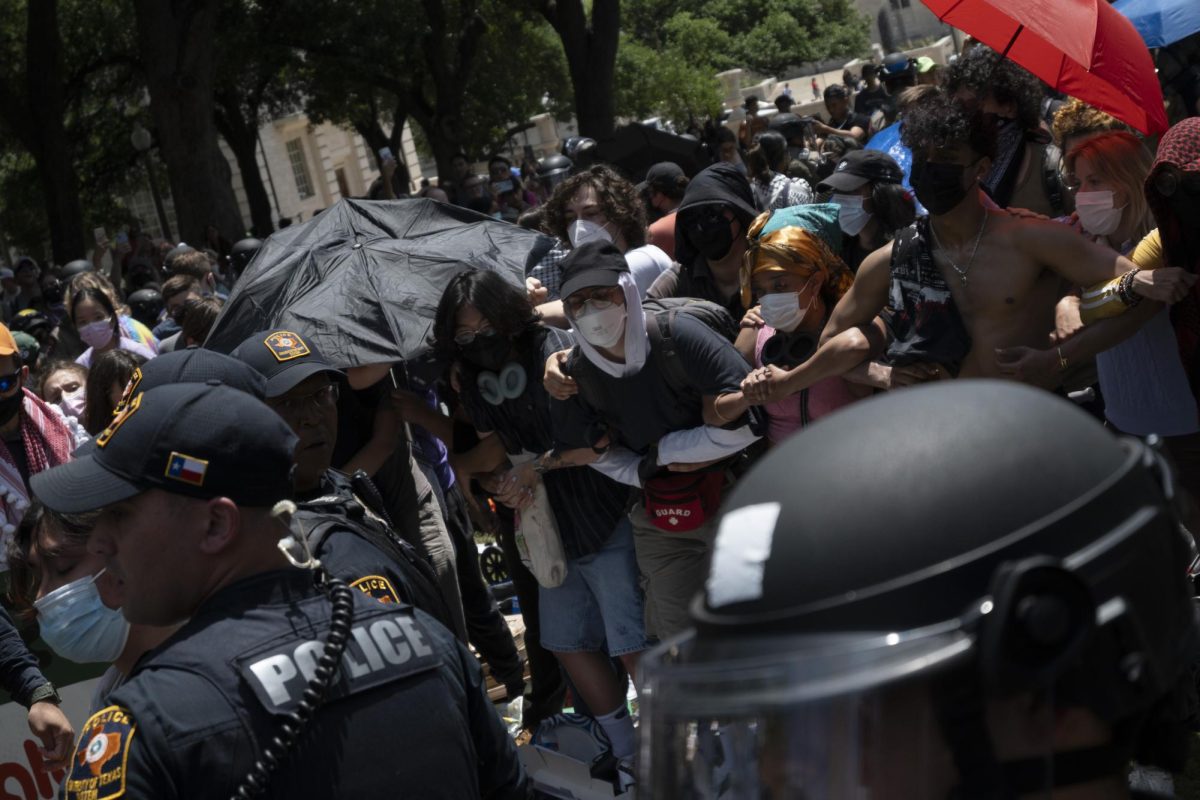 Members of an encampment on April 29 link arms as police officers work their way through the crowd in attempt to disperse the circle on UT Austins campus.