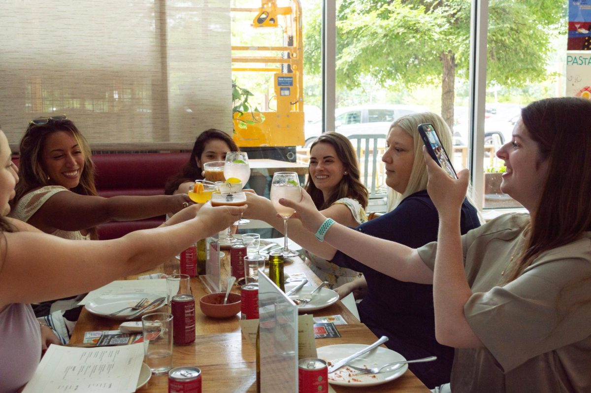 Samantha Leonard films a video clinking glasses with attendees of Sunday’s “A Taste of Italy” brunch at L’oca d’Oro in Mueller, hosted by her social group ATX Brunch Girls.