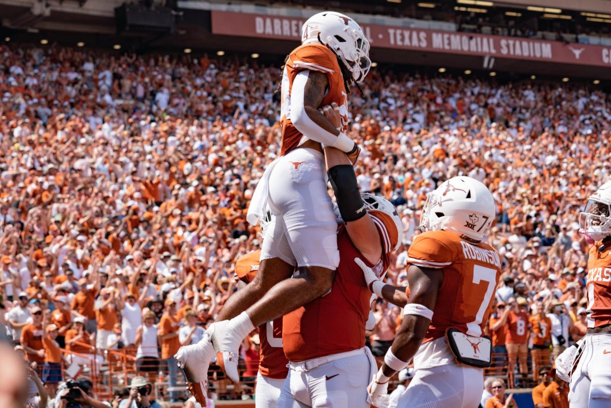 Sophomore Jonathon Brooks celebrates with his teammates after scoring the first touchdown during Texas game against Rice on Sept. 2, 2023. 