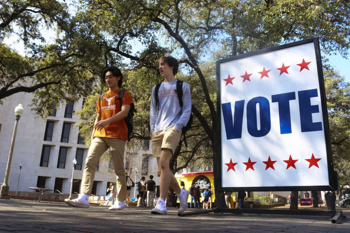 Students walk past a "Vote" sign in front of the PCL on Feb. 22, 2022.