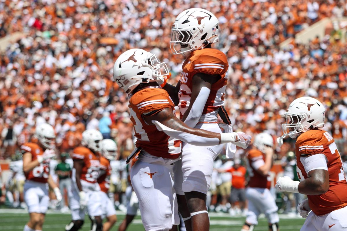 Running back Quintrevion Wisner hugs Jaydon Blue after scoring a touchdown during the game against Colorado State on Saturday.