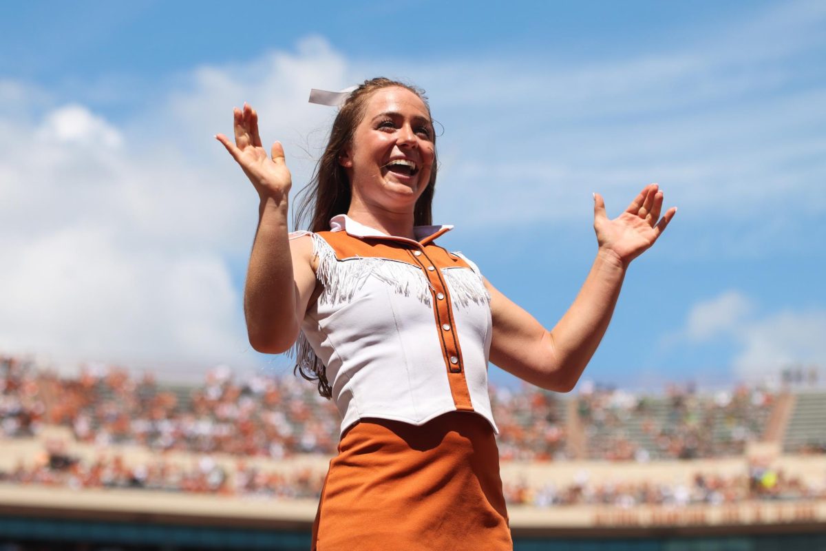 Junior Ellie Becker smiles during a stunt at the game against Colorado State on Saturday.