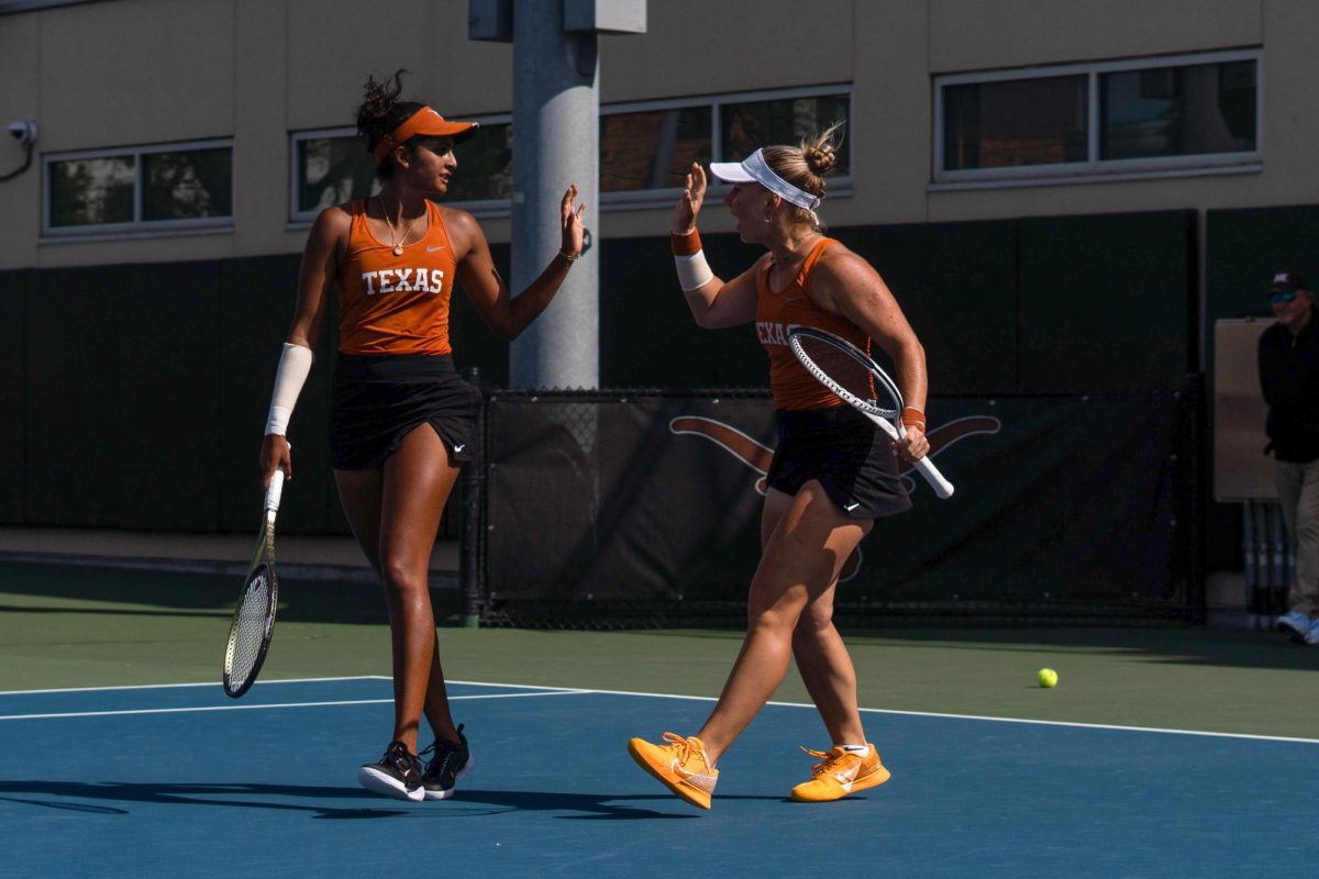 Malaika Rapolu and Tanya Sasnouskaya high five after winning a set against Oklahoma on March 3.