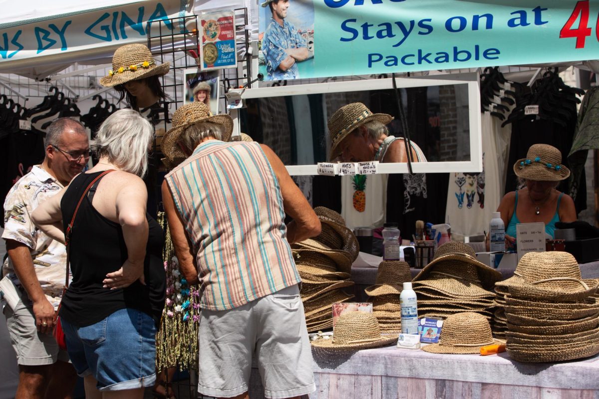 Festivalgoers try on vendor BG Hats' seagrass merchandise at Pecan Street Fest in downtown Austin on Saturday, Sept. 14, 2024. This fall commemorated its 47th year.