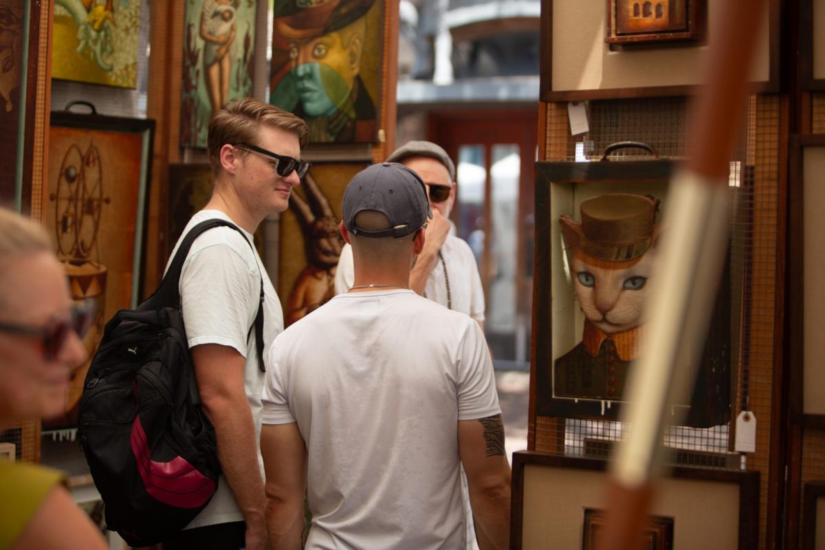 People peruse an artists' booth at the 47th Fall Pecan Street Festival in downtown Ausitn on Saturday, Sept. 14, 2024. Artisan craftsmanship was a main focus of many vendors, in addition to food and beverages.