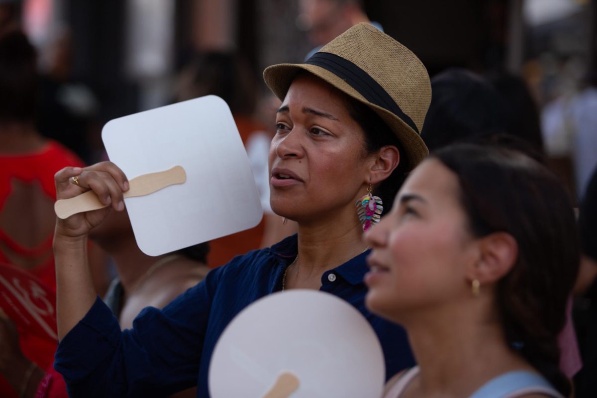 Festivalgoers cool off with fans as temperatures reach the high ninties during the outdoor Pecan Street Fest in downtown Austin on Saturday, Sept. 14, 2024.