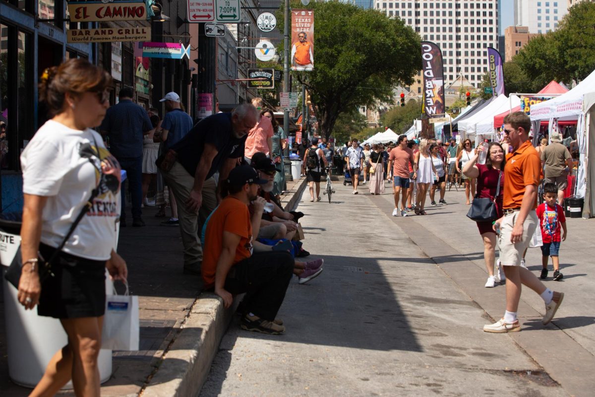 People walk along Sixth Street during the biannual Pecan Street Fest in Austin on Saturday, Sept. 14, 2024.