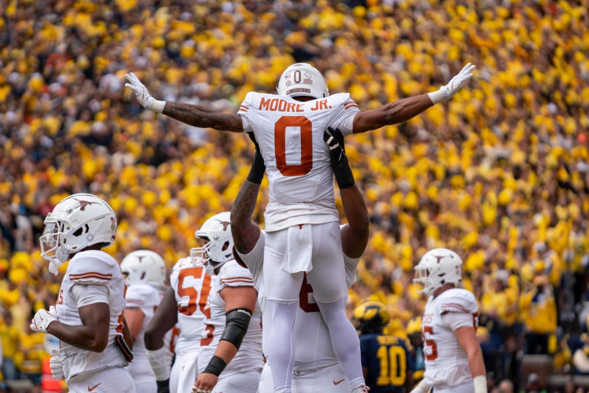 Wide receiver DeAndre Moore Jr. is lifted by offensive lineman Kelvin Banks Jr. in celebration after a play during Texas' game at Michigan on Sept. 7, 2024.