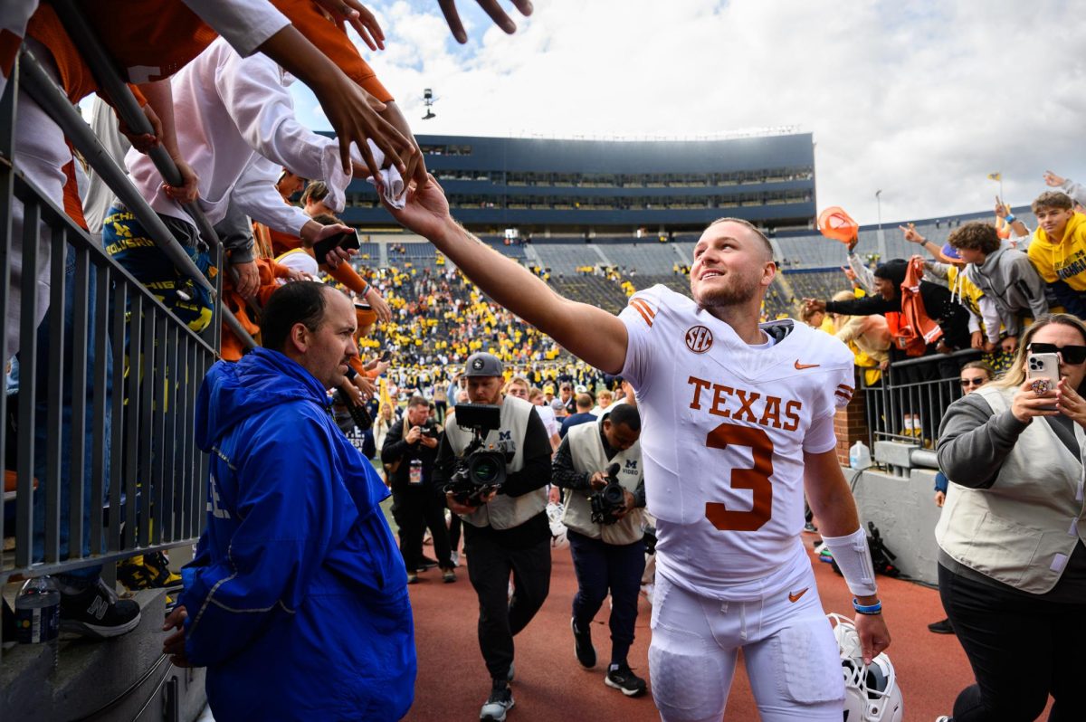 Texas quarterback Quinn Ewers gives a fan his towel after the Texas vs. Michigan Football game at Michigan Stadium on Sept. 7, 2024. Texas won 31-12.