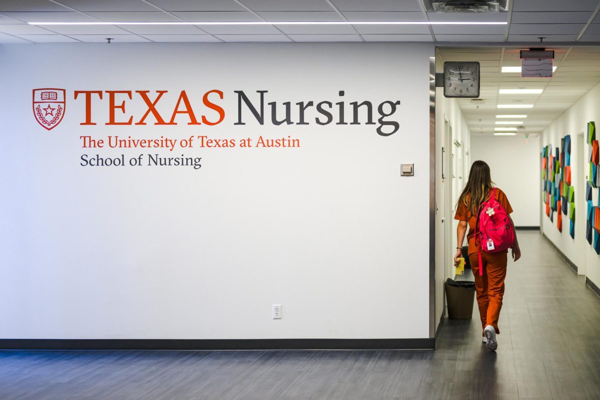 A student in burnt orange scrubs walks through the UT Austin School of Nursing on Wednesday, Sept. 23, 2024.