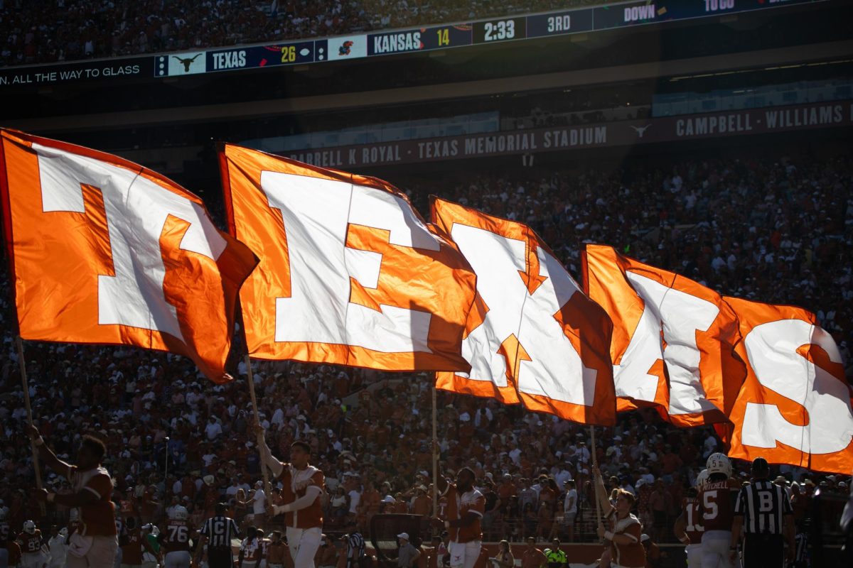 Texas cheerleaders carry the Texas letter flags after the Longhorns score during their game against the Jayhawks on Sept. 30, 2023. Texas won 40-14.