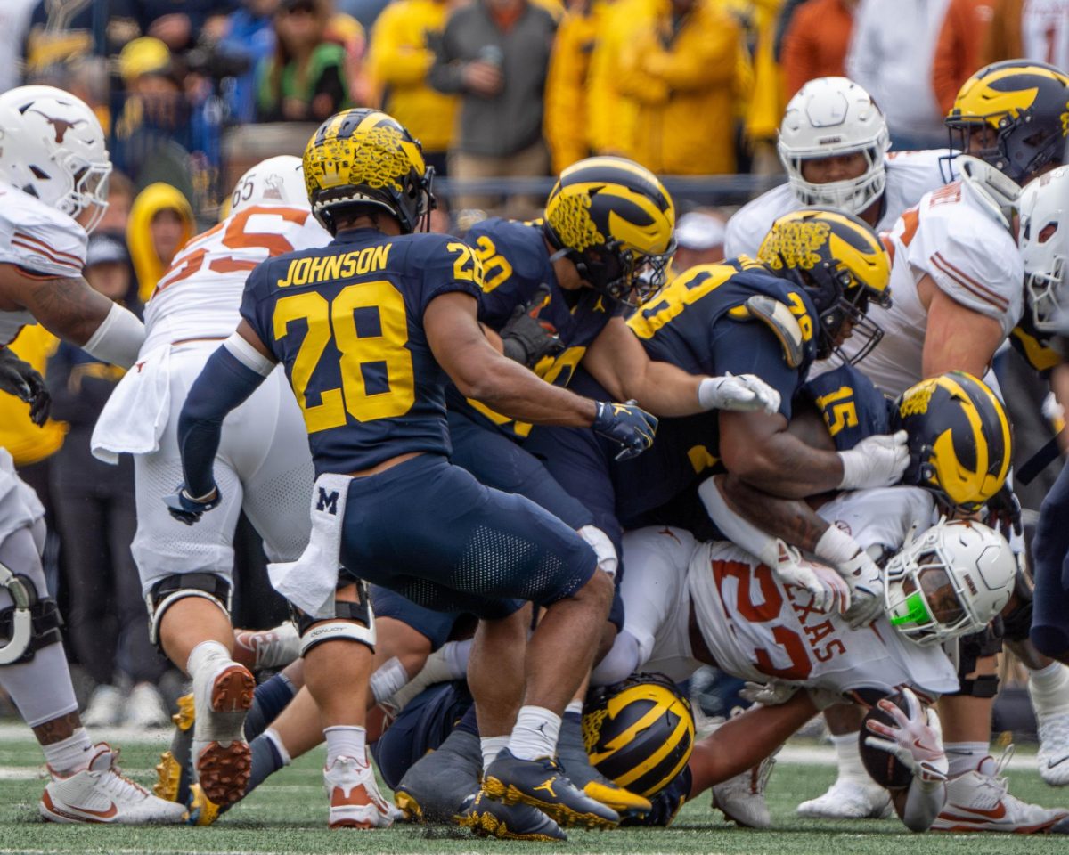 Running back Jaydon Blue is tackled by three defenders during Texas' game at Michigan on Sept. 7, 2024. 