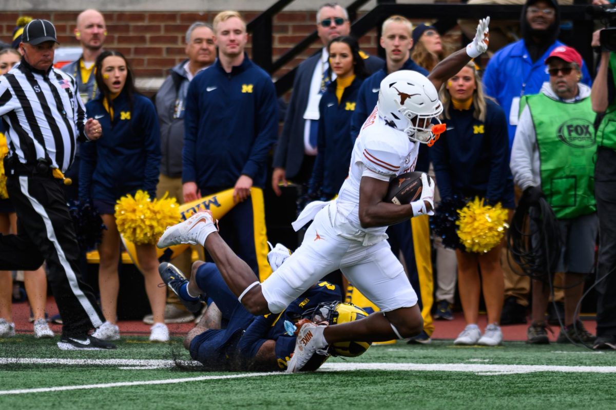 Texas wide receiver Ryan Wingo runs the ball during the Texas vs. Michigan Football game at Michigan Stadium on Saturday.