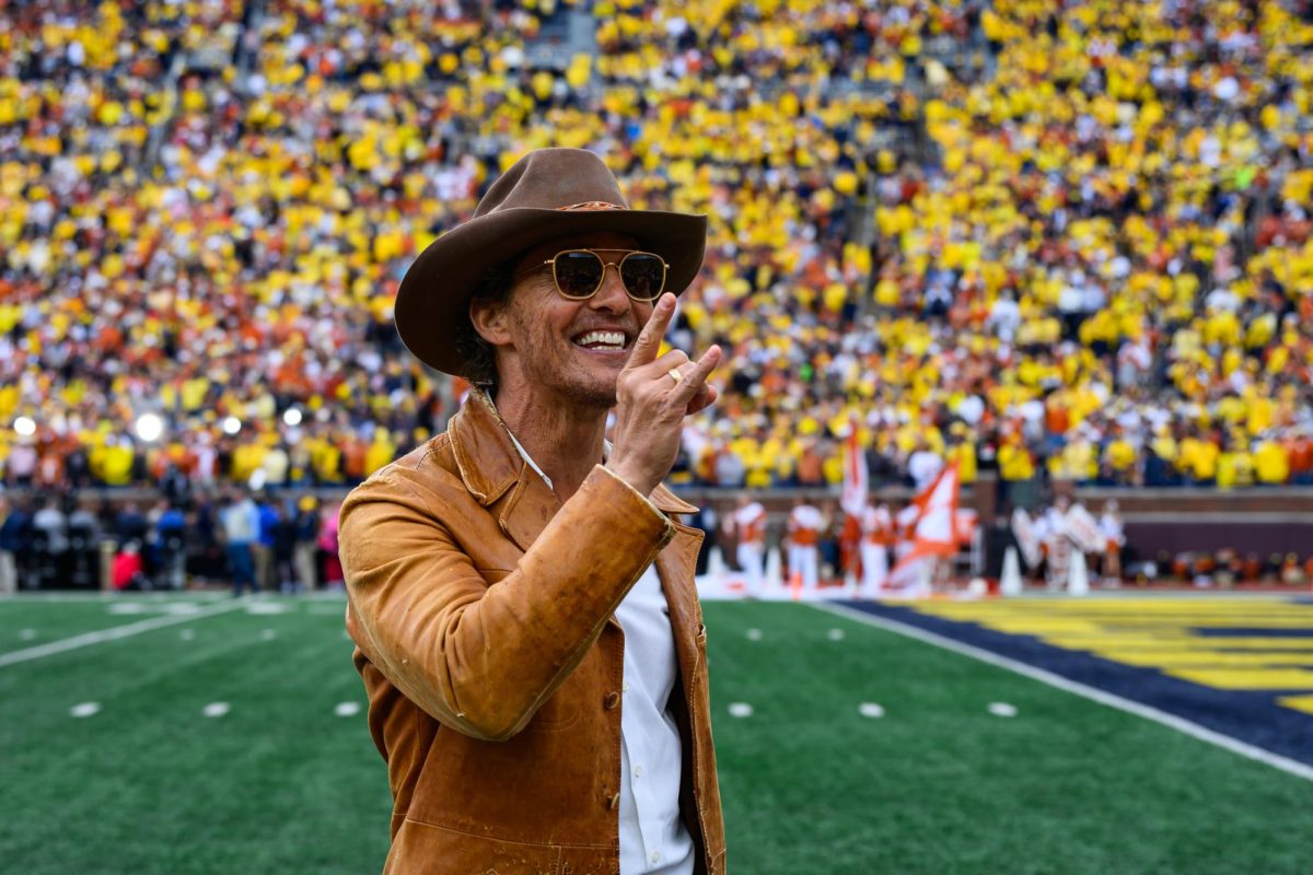 Mathew McConaughey raises a "Hook 'Em" hand sign at the Texas vs. Michigan Football game at Michigan Stadium on Saturday.