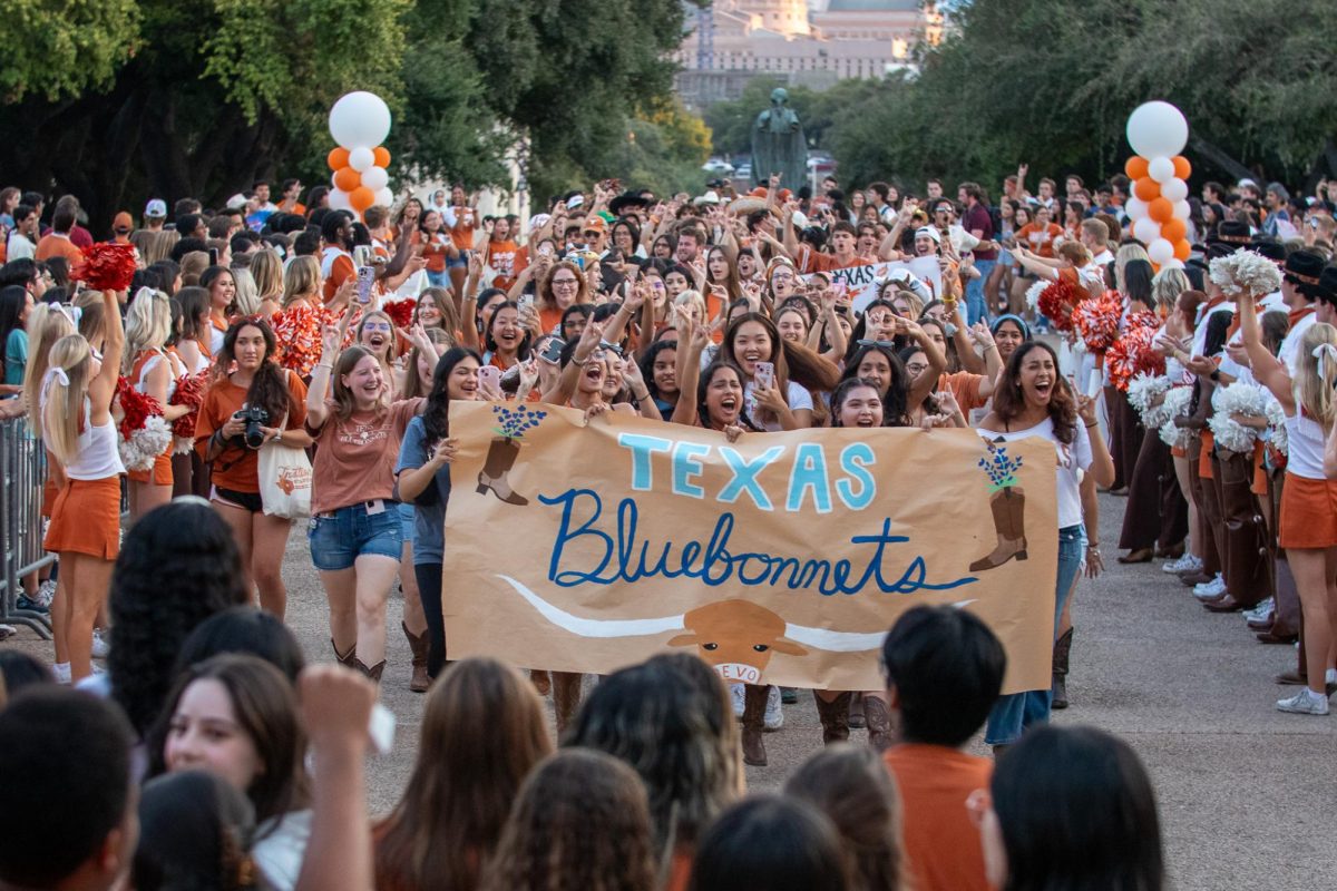 The Texas Bluebonnets cheer as they walk towards the tower for the Texas Fight Rally on Oct. 9, 2024.