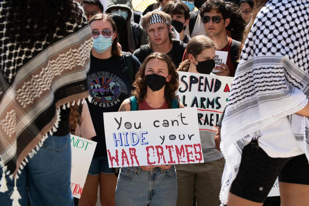 A protester holds up a sign at the Palestine Solidarity Committee’s walkout calling for the University to divest from weapons manufacturers outside the UT Tower on October 10, 2024. The University placed the PSC on interim suspension after April's pro-Palestine demonstrations; However, UTPD and school officials allowed the organization to peacefully protest on Oct. 10, 2024.