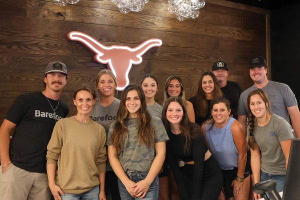 Barefoot Outfitters employees smile behind the checkout counter during the grand opening of their store on Oct. 17, 2024.