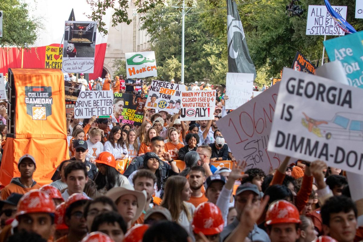 Signs and flags are held above the crowd at College GameDay on Oct. 19, 2024.
