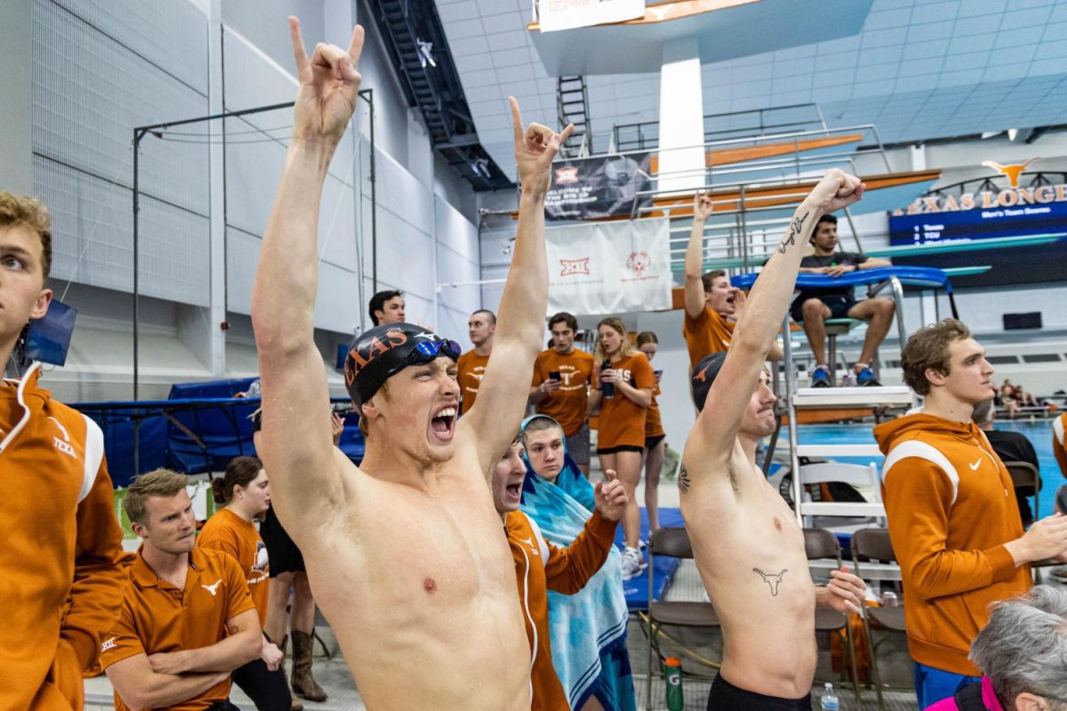 Texas swimmers cheer as their teammates compete in the Big 12 Swimming and Diving Championship at the Lee and Joe Jamail Texas Swimming Center on Feb. 25, 2022. The University of Texas was named Big 12 Champions for men's and women's events. 