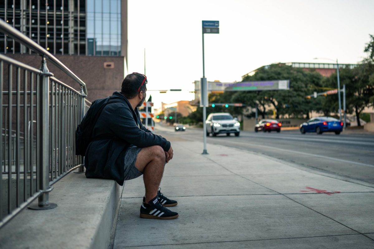 Derek Hernandez watches for Bus 18 at the stop at the corner of Martin Luther King and San Jacinto boulevards on Oct. 31, 2024. This stop is one of many without a roof or seating. 