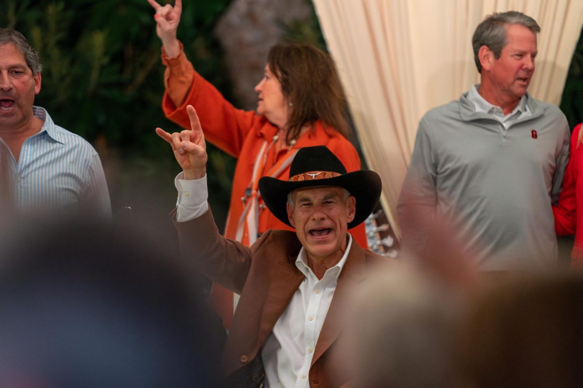 Governor Greg Abbott sings "The Eyes of Texas" onstage during a tailgate for the UT-Georgia football game at the Governor's Mansion on Oct. 18, 2024. 