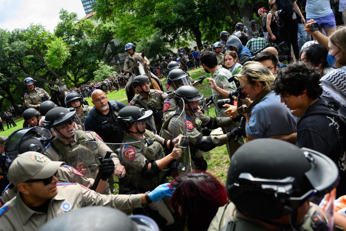 Law enforcement pushes protesters to the edge of the Main Mall lawn with riot shields and batons during the pro-Palestine student walkout on Wednesday, April 24, 2024. 