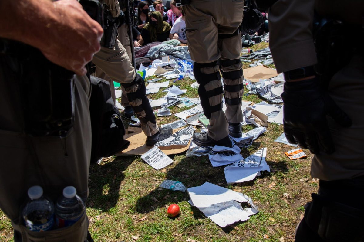 Flyers lay scattered on South Mall lawn as law enforcement officers break up a pro-Palestine encampment on April 29, 2024.