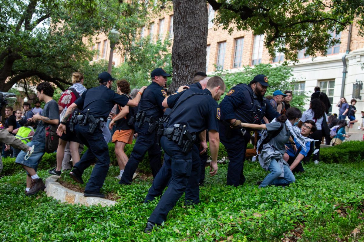 Five UTPD officers arrest a protester on the side of Speedway on April 24, 2024.