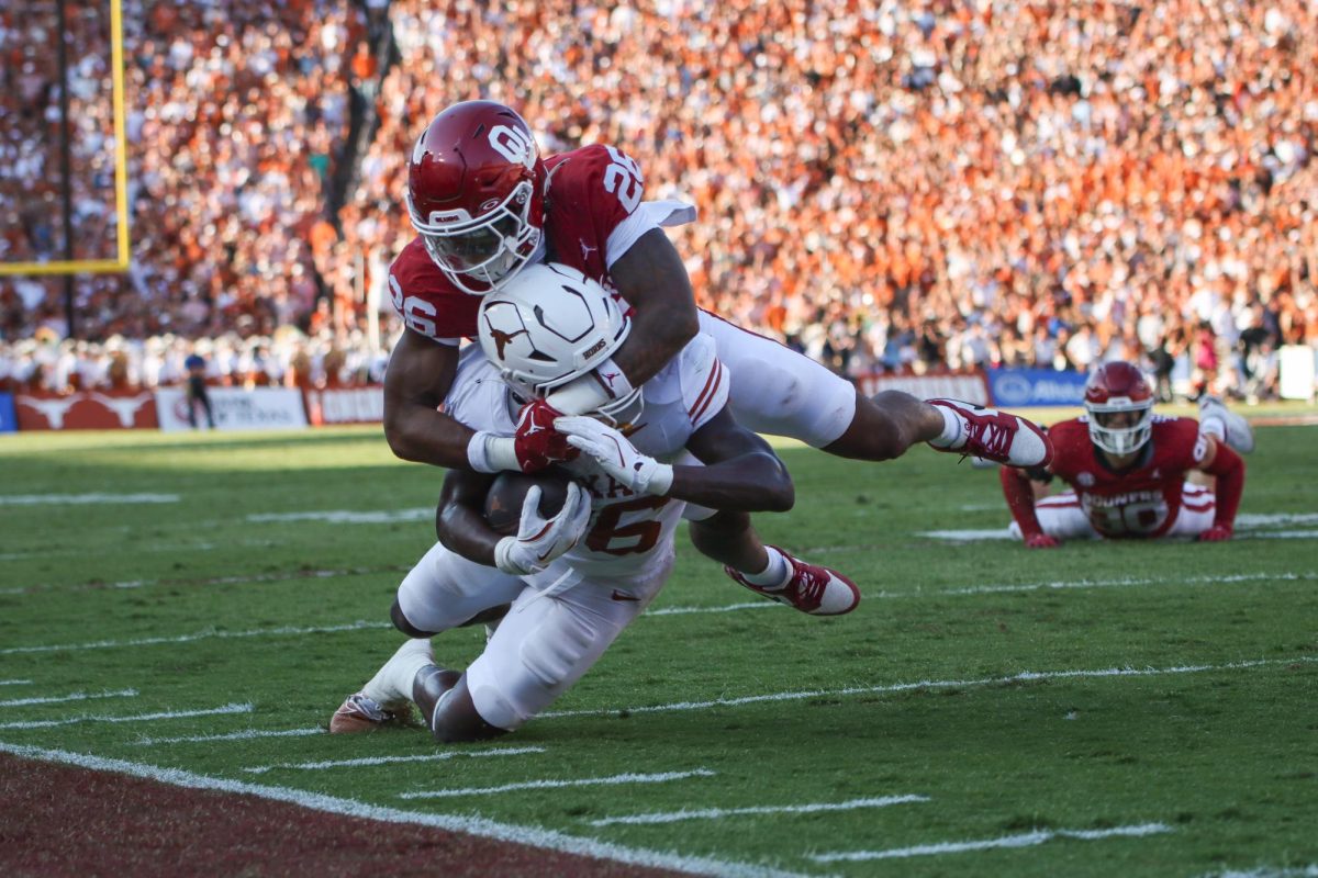 Runningback Quintrevion Wisner gets tackled by Oklahoma defensive back Kani Walker during the Red River Rivalry game on Oct. 12, 2024.