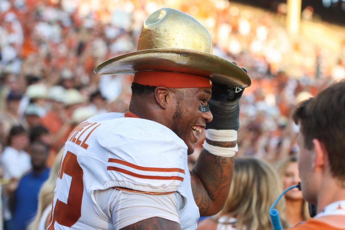 Offensive lineman DJ Campbell smiles as he puts the golden hat on his head after Texas' victory in the Red River Rivalry on Oct. 12, 2024.