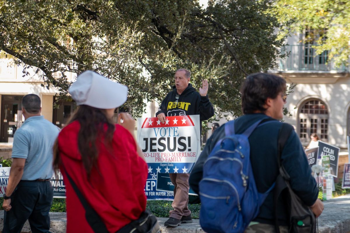 Abigail Reyna watches as Pastor David Grisham tells people to vote on Nov. 5, 2024. Reyna wears an outfit inspired by The Handsmaid’s Tale, a book by Margaret Atwood.