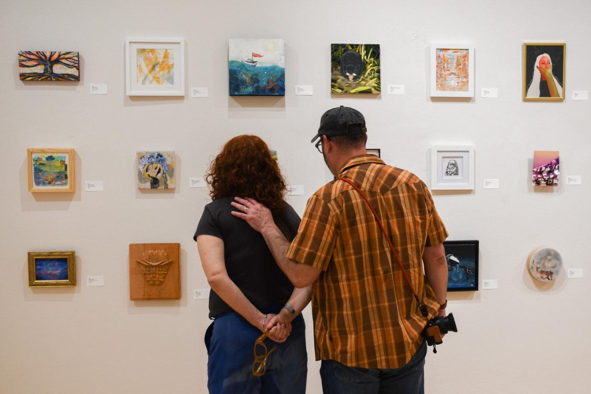 A couple looks at a Austin Studio Tour art display at the George Washington Carver Museum and Cultural Center on Nov. 10, 2024.