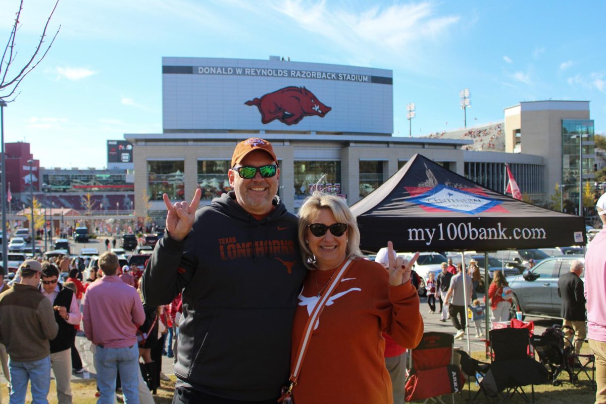 Longhorn fans Kelly Devetter and her husband pose in front of the Razorback Stadium before the Texas-Arkansas game on Nov. 16, 2024. 