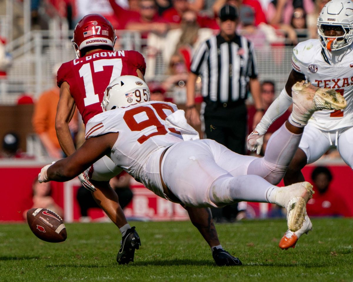 Defensive lineman Alfred Collins forces a fumble by Arkansas wide receiver CJ Brown during the fourth quarter of Texas' game against Arkansas on Nov. 16, 2024. 