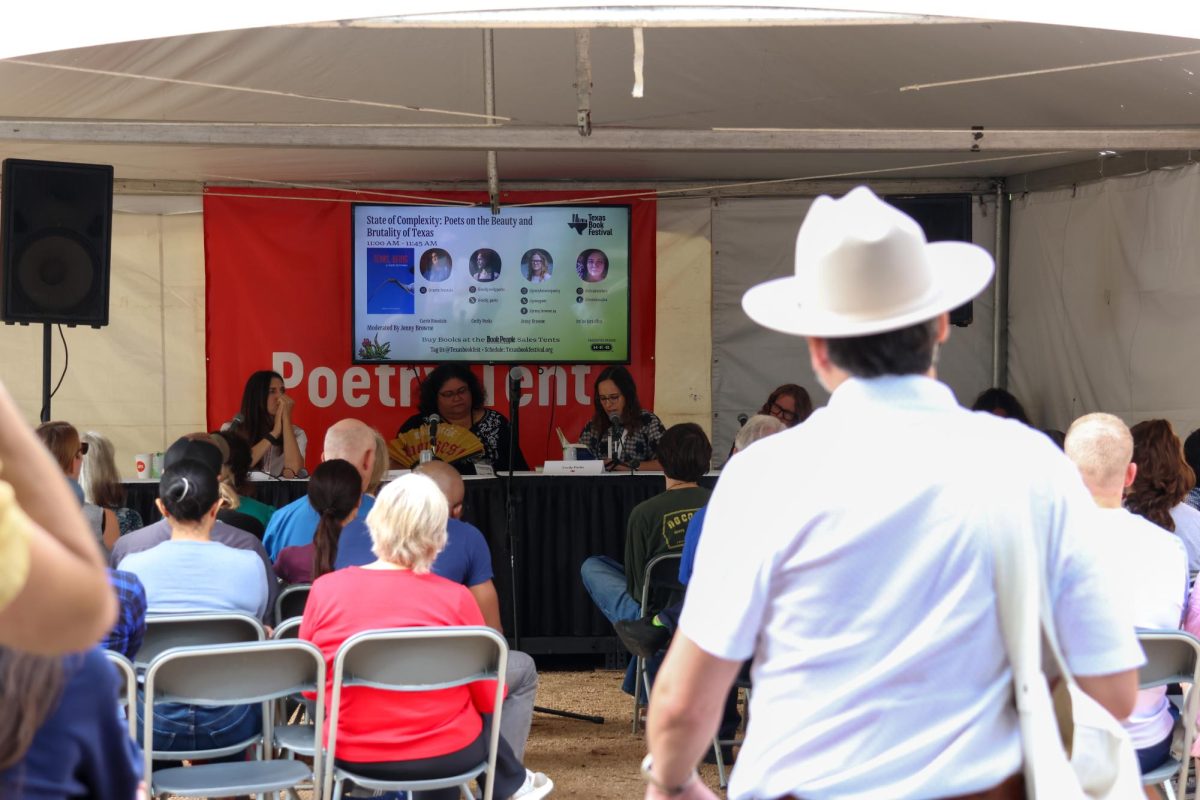 A man stops in his tracks to listen to Cecily Parks recite a poem from the book Texas, Being: A State of Poems at the Texas Book Festival on Nov. 17, 2024.