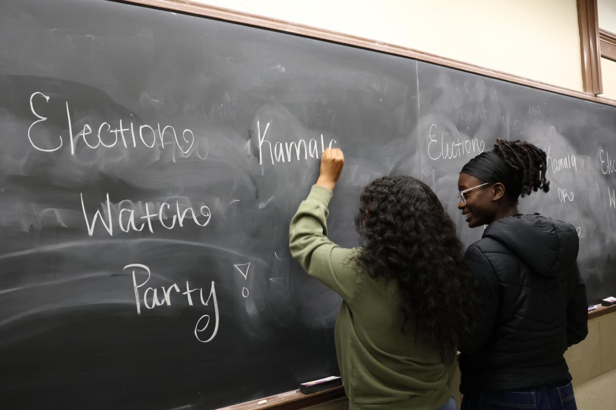 UT's Freshman Action Team's Political Action Committee Officer Harmony Jones writing on a chalkboard in Garrison Hall before the Election Watch Party on November 5, 2024.